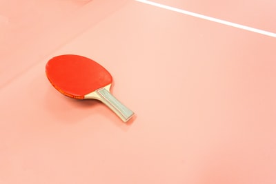 一个红色的乒乓球桨坐在法庭上。
